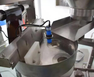 Detalle da máquina de envasado de selado traseiro: medición de vasos volumétricos